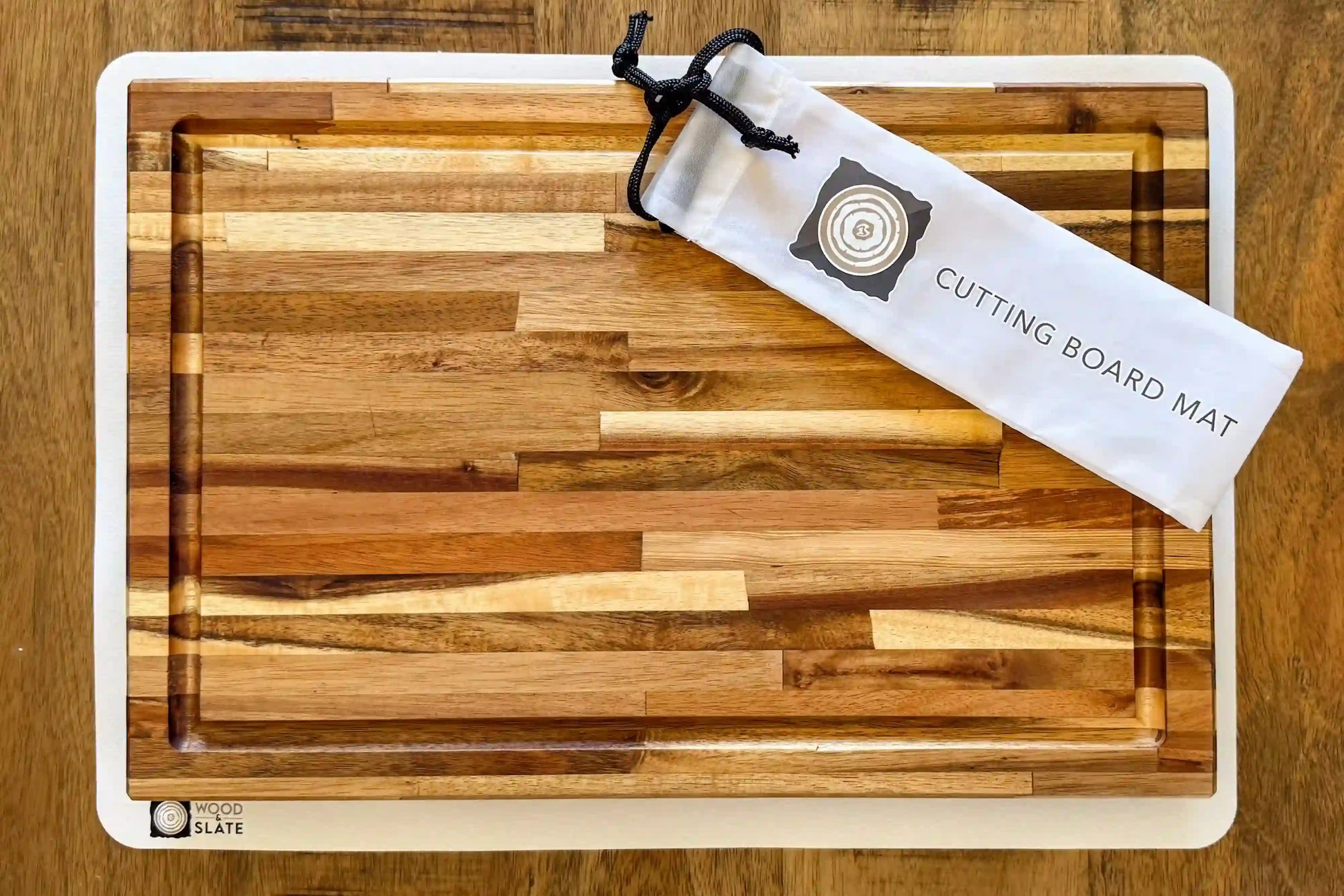 Wooden cutting board with a branded mat on a wooden surface