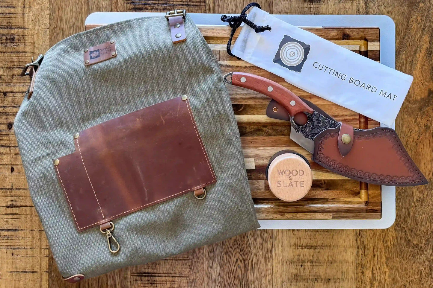 Green leather bag with brown leather accents on a wooden surface, accompanied by a cutting board mat and knife.